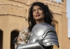 A woman in a suit of armor carries a bunny rabbit A woman in a suit of armor carries a bunny rabbit
