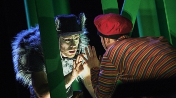 A dancer dressed as The Wolf reaches out to touch Peter's hand A dancer dressed as The Wolf reaches out to touch Peter's hand