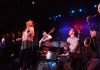 A jazz band with a female lead singer, in a dimly lit and atmospheric room A jazz band with a female lead singer, in a dimly lit and atmospheric room