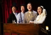 4 actors dressed in period vaudevillian clothes, in the act of singing energetically 4 actors dressed in period vaudevillian clothes, in the act of singing energetically