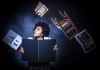 A woman holding a large book looks up a flying objects, such as a chair and other books A woman holding a large book looks up a flying objects, such as a chair and other books