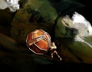 A mechanical puppet pushes a wooden boulder in front of a brooding, swirling sky A mechanical puppet pushes a wooden boulder in front of a brooding, swirling sky