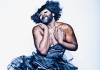 La Gateau Chocolat, a bearded black man with glitter in his hair, in a low cut black dress La Gateau Chocolat, a bearded black man with glitter in his hair, in a low cut black dress