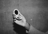 Black and white. A hand holding a compact mirror. Black and white. A hand holding a compact mirror.