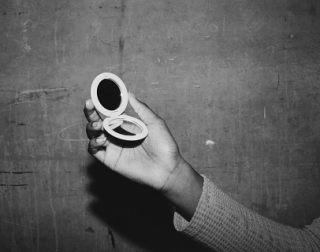 Black and white. A hand holding a compact mirror. Black and white. A hand holding a compact mirror.