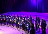 A student chamber choir, lit in purple lighting A student chamber choir, lit in purple lighting