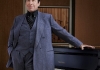 Jools Holland in a blue suit standing in front of a black piano Jools Holland in a blue suit standing in front of a black piano