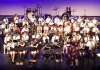A group of school children perform in an orchestra onstage A group of school children perform in an orchestra onstage