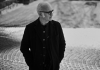 A black and white photo of Ludovico in a long black coat A black and white photo of Ludovico in a long black coat