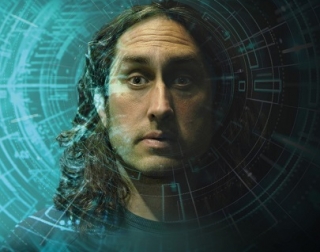 A man's face, half in shadow, on a green background A man's face, half in shadow, on a green background