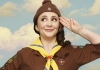 A woman in a Brownies uniform saluting in front of a sky background A woman in a Brownies uniform saluting in front of a sky background