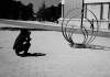 A person crouches down to take a photograph of a sculpture. Black and white. A person crouches down to take a photograph of a sculpture. Black and white.