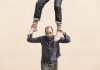 Man looks at camera whilst holding someone on his shoulders Man looks at camera whilst holding someone on his shoulders