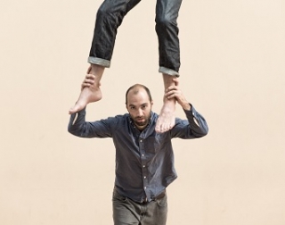 Man looks at camera whilst holding someone on his shoulders Man looks at camera whilst holding someone on his shoulders