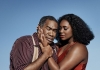 A man and a woman embrace against a blue sky in the background A man and a woman embrace against a blue sky in the background