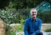Man smiles whilst sitting in a garden Man smiles whilst sitting in a garden