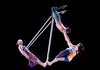 4 people hang from an aerial swing against a black background 4 people hang from an aerial swing against a black background