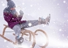 A child in a woolly hat, scarf, coat and boots rides on a wooden sledge in the snow A child in a woolly hat, scarf, coat and boots rides on a wooden sledge in the snow