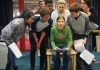 A group of children huddle around each other performing holding scripts. A group of children huddle around each other performing holding scripts.