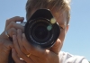 Man holding camera against a blue sky Man holding camera against a blue sky