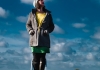 A woman in a coat and a hat stands on a metal ladder, looking at the stars. A woman in a coat and a hat stands on a metal ladder, looking at the stars.