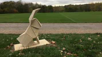 An origami hare set in the middle of a green field. An origami hare set in the middle of a green field.
