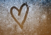 A heart drawn on a misty glass window. A heart drawn on a misty glass window.