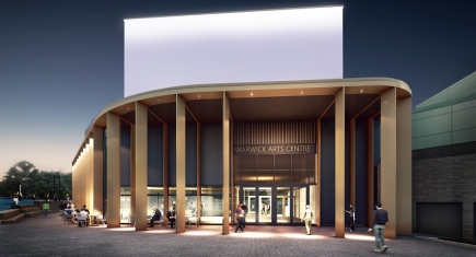 An artist's impression of Warwick Arts Centre during the evening. It shows the outside of a building with beams supporting the roof, with a sign above the glass doors reading "Warwick Arts Centre" and people sitting on cafe chairs and tables outside. The building is illuminated. An artist's impression of Warwick Arts Centre during the evening. It shows the outside of a building with beams supporting the roof, with a sign above the glass doors reading "Warwick Arts Centre" and people sitting on cafe chairs and tables outside. The building is illuminated.
