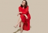 A woman sat down in a red dress on a beige background A woman sat down in a red dress on a beige background