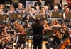An orchestra playing string and woodwind instruments. An orchestra playing string and woodwind instruments.