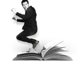 A black and white image of comedian Rhod Gilbert jumping out of a large, open book A black and white image of comedian Rhod Gilbert jumping out of a large, open book