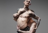 A photo of a man carrying another man who is topless with tattoos A photo of a man carrying another man who is topless with tattoos