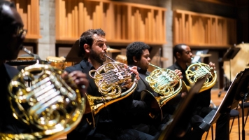 An image of four men sat playing the french horn An image of four men sat playing the french horn