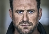 A tight crop on a man's face as he looks into the camera with a serious expression. A tight crop on a man's face as he looks into the camera with a serious expression.