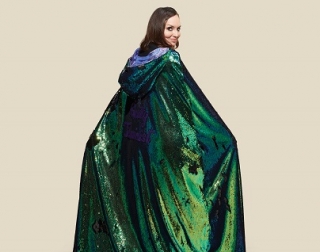 An image of a woman wearing a sparkly green cape An image of a woman wearing a sparkly green cape