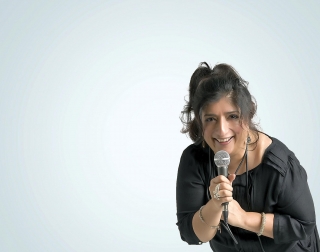 Sajeela Kershi smiling and holding a microphone Sajeela Kershi smiling and holding a microphone