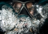 An underwater mask with water bubbles surrounding it An underwater mask with water bubbles surrounding it