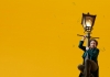 Actor Rory Kinnear hangs from an old fashioned lamppost in front of a bright yellow background Actor Rory Kinnear hangs from an old fashioned lamppost in front of a bright yellow background