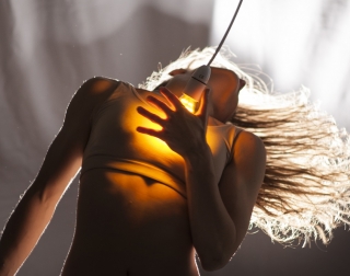 Female dancer holding a light bulb to her chest Female dancer holding a light bulb to her chest