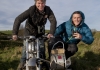 TV presenters Martin Hughes-Games and Iolo Williams on a motorbike and side-car driving through a muddy field TV presenters Martin Hughes-Games and Iolo Williams on a motorbike and side-car driving through a muddy field