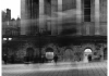 A moody black and white photograph showing a cobbled street and stone pillared building A moody black and white photograph showing a cobbled street and stone pillared building