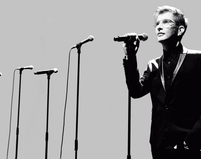 Black and white picture Gareth Malone standing next to several mic stands Black and white picture Gareth Malone standing next to several mic stands