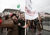 Women wearing long coats march and carry banners Women wearing long coats march and carry banners