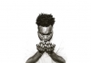 A young man of colour wearing a white t-shirt and looking down at his hands A young man of colour wearing a white t-shirt and looking down at his hands