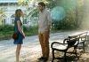 A young man and a woman standing in front of each other in a sunny park A young man and a woman standing in front of each other in a sunny park