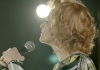 Side profile of a blonde woman, defiantly clutching a microphone Side profile of a blonde woman, defiantly clutching a microphone