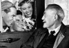 Black and white photo of an old man in a car conversing with a group of hitchhikers Black and white photo of an old man in a car conversing with a group of hitchhikers