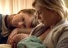 A young woman watches on as a mother breastfeeds her baby A young woman watches on as a mother breastfeeds her baby