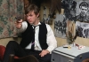 Young boy wearing a school uniform pointing a revolver at someone offscreen Young boy wearing a school uniform pointing a revolver at someone offscreen