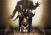 Four actors on a stage with an ominous shadow of a ghost behind them Four actors on a stage with an ominous shadow of a ghost behind them